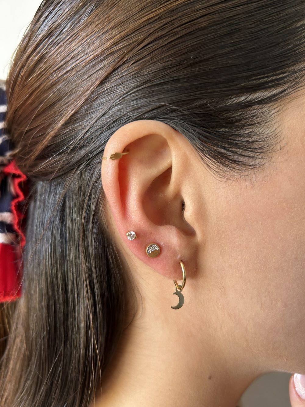 Mujer luciendo aros bicolores de oro con circones